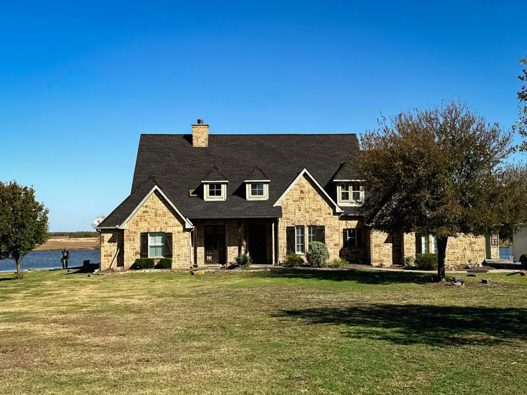 Brick home with a new roof installed by All Pro Roofing